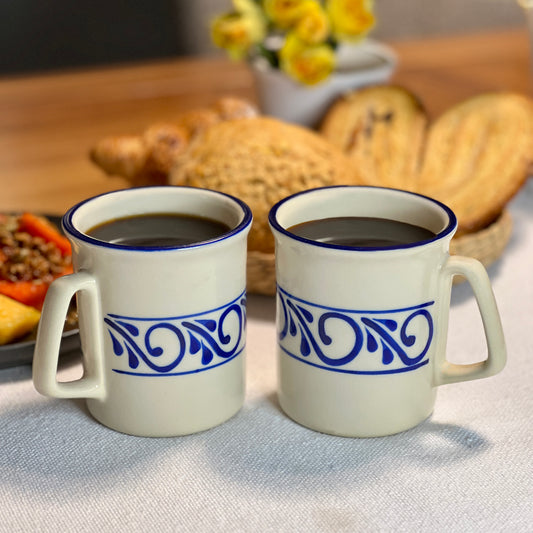 Set of two ceramic mugs with hand-painted designs, ideal for enjoying morning coffee or tea.